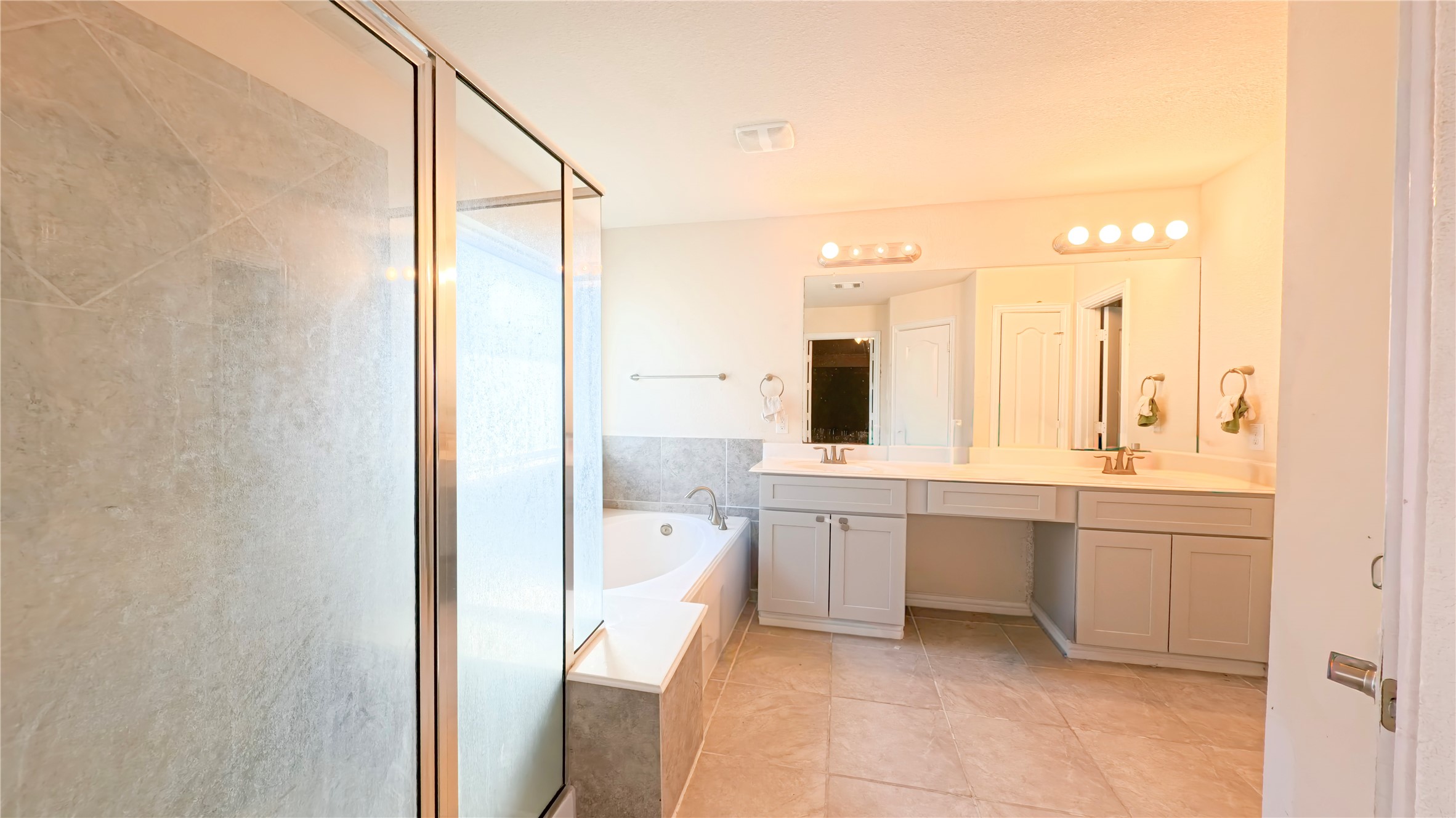 9707 Shimmering Lakes Drive Rosharon, TX 77583 - Photo 16 of 19 a large bathroom with a double vanity sink a large mirror and a bathtub