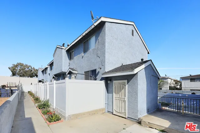 a view of a house with wooden fence