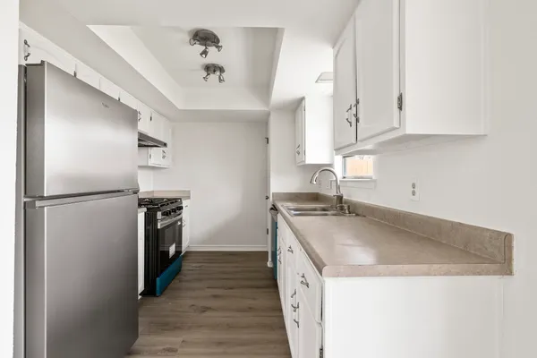 a kitchen with granite countertop a sink and a refrigerator