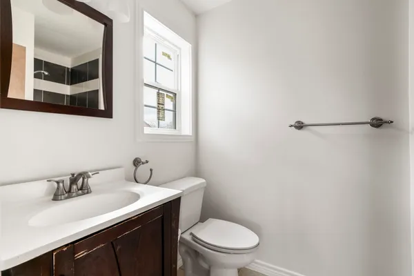 a bathroom with a sink vanity mirror and toilet