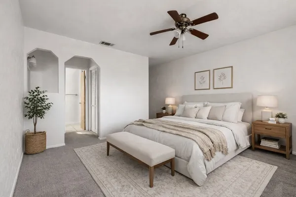 a bedroom with a bed and a potted plant