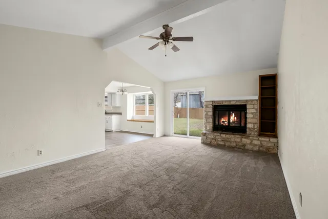 a view of an empty room with a fireplace and a window