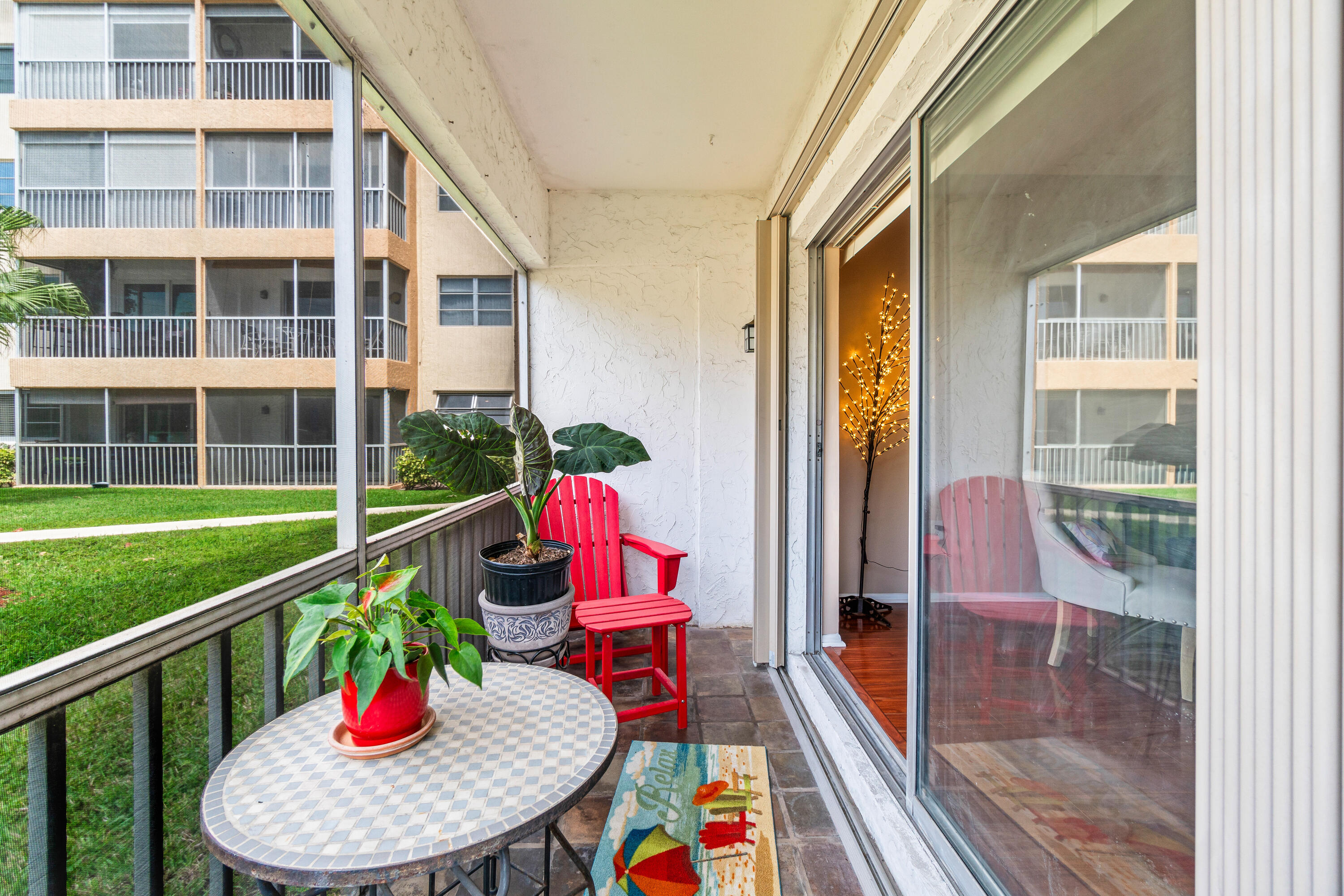 290 West Palmetto Park Road, Unit 114 Boca Raton, FL 33432 - Photo 21 of 25 a view of a balcony with a dining table and chairs with wooden floor