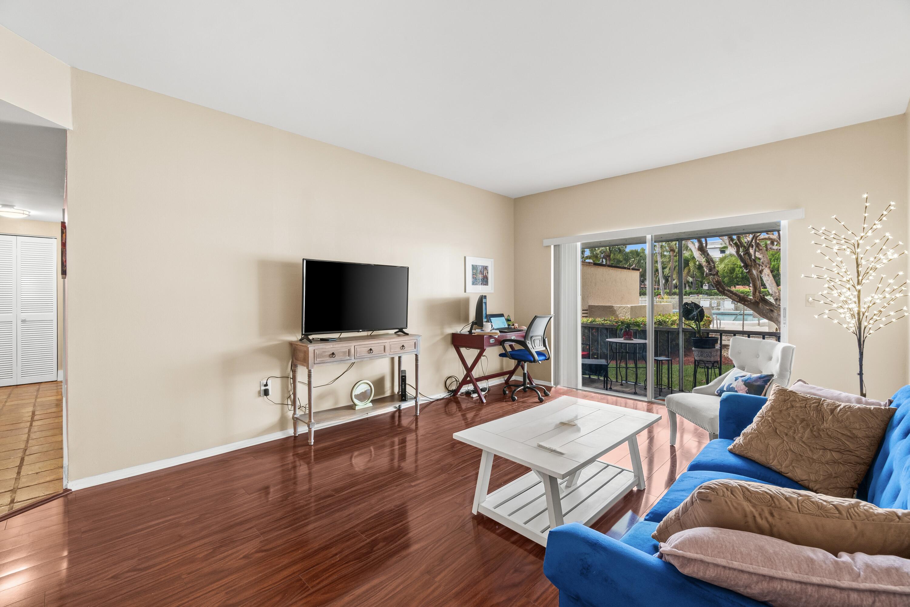 290 West Palmetto Park Road, Unit 114 Boca Raton, FL 33432 - Photo 9 of 25 a living room with furniture and a flat screen tv