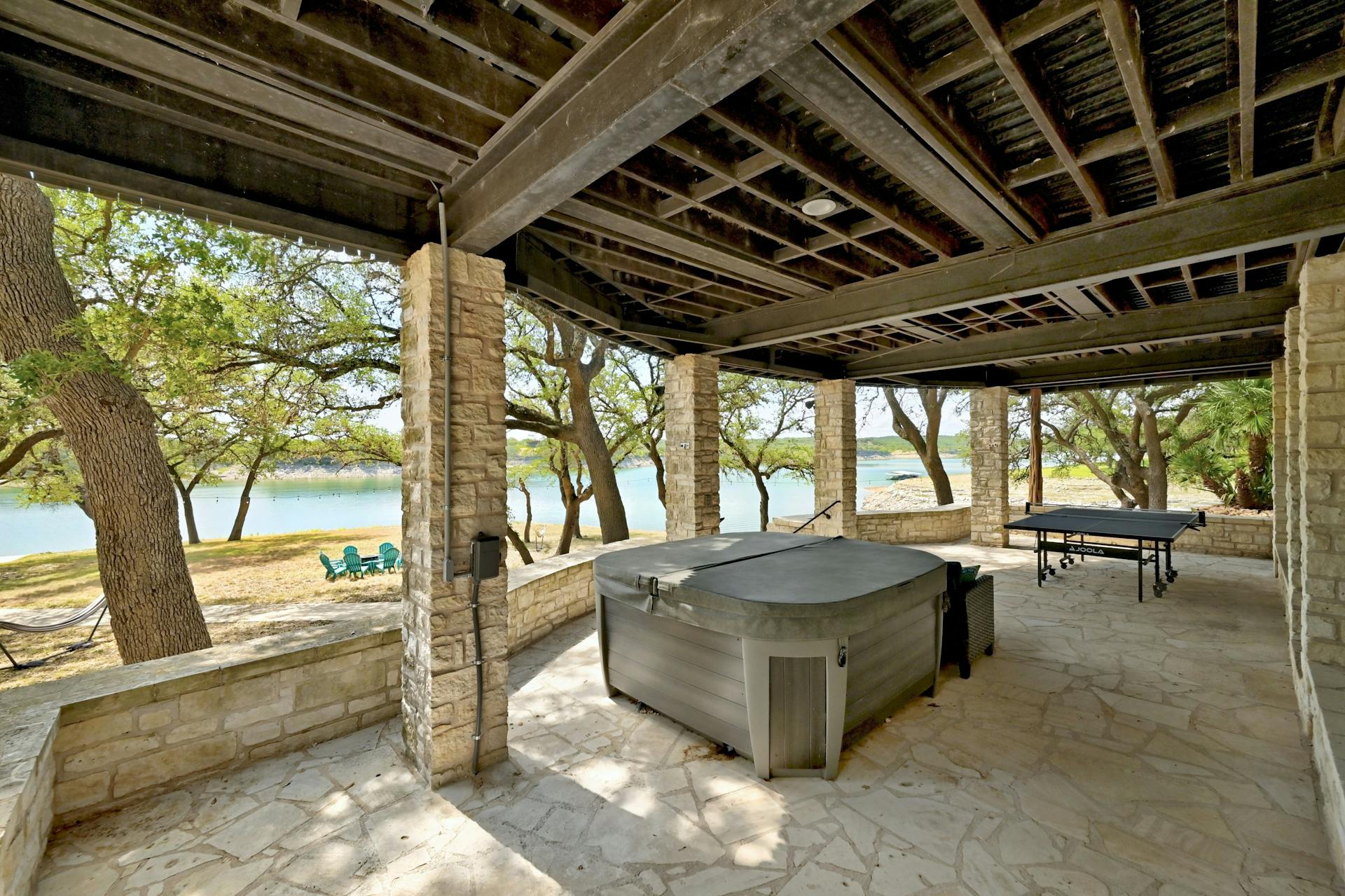 6021 Circle J Road Marble Falls, TX 78654 - Photo 15 of 39 View of patio / terrace with a water view, outdoor dining area, and a hot tub