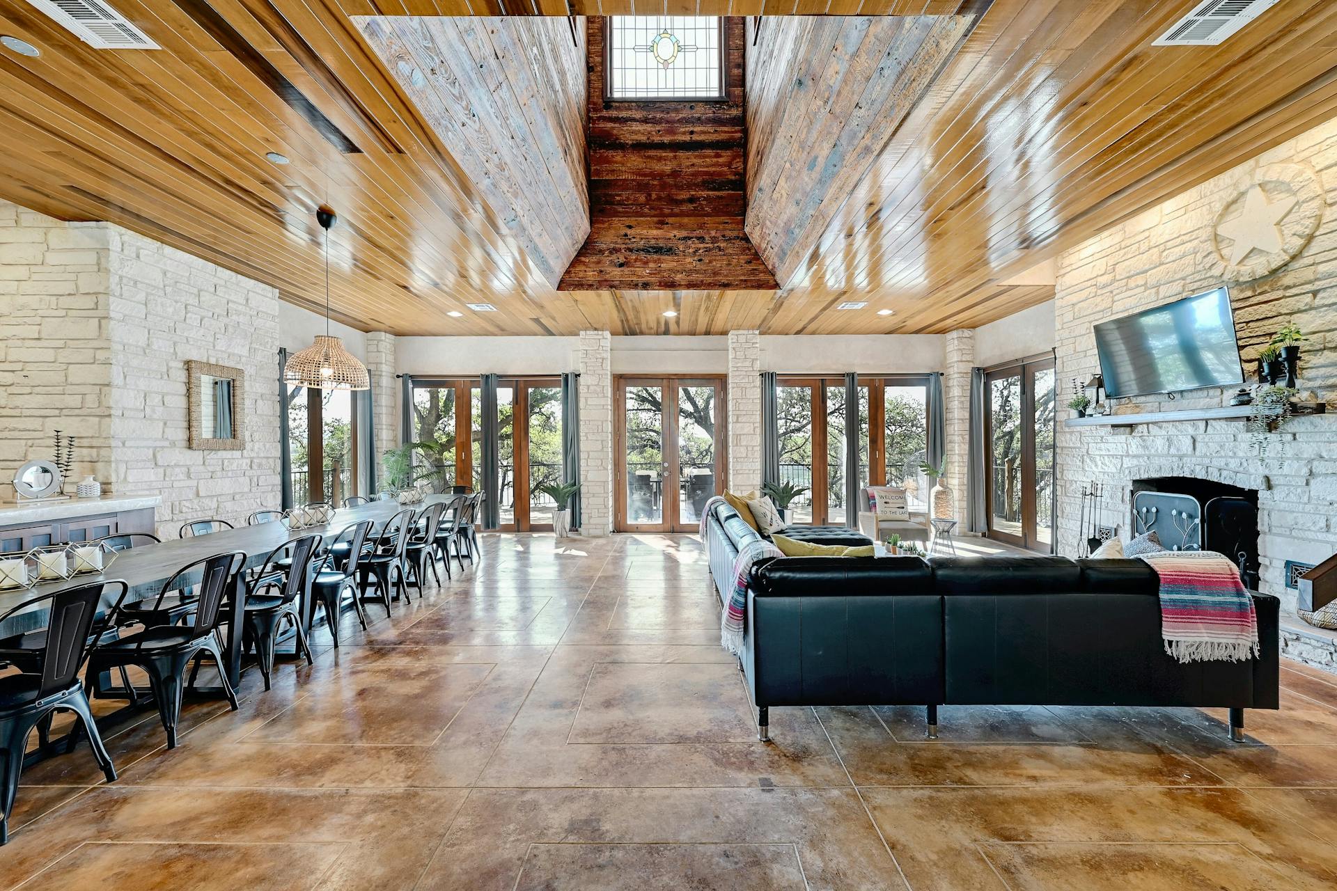 6021 Circle J Road Marble Falls, TX 78654 - Photo 19 of 39 Living area featuring french doors, wood ceiling, a fireplace, and concrete flooring