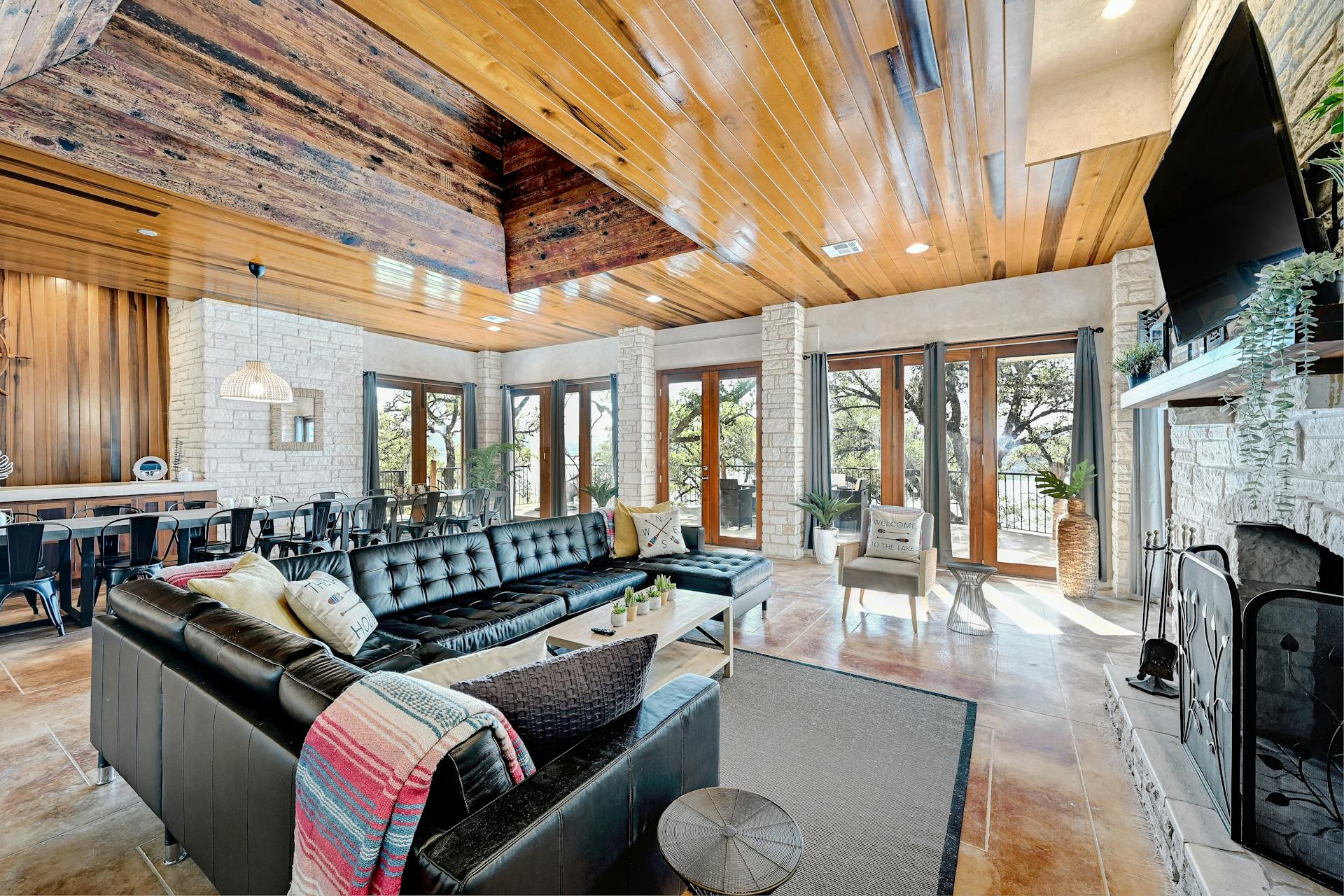 6021 Circle J Road Marble Falls, TX 78654 - Photo 23 of 39 Living room with a stone fireplace, wood ceiling, wood walls, and french doors