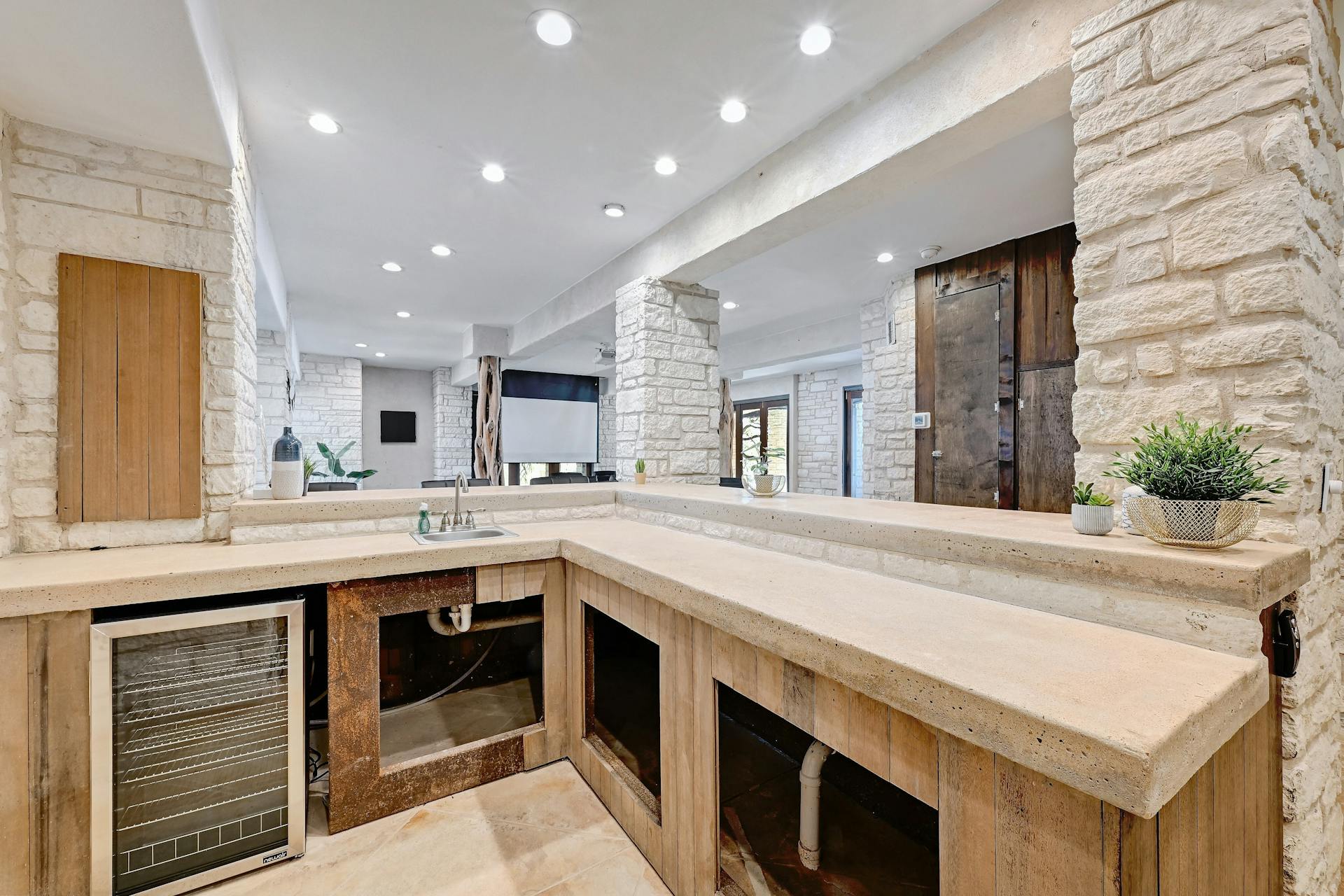 6021 Circle J Road Marble Falls, TX 78654 - Photo 31 of 39 Indoor wet bar with wine cooler, light stone counters, and recessed lighting