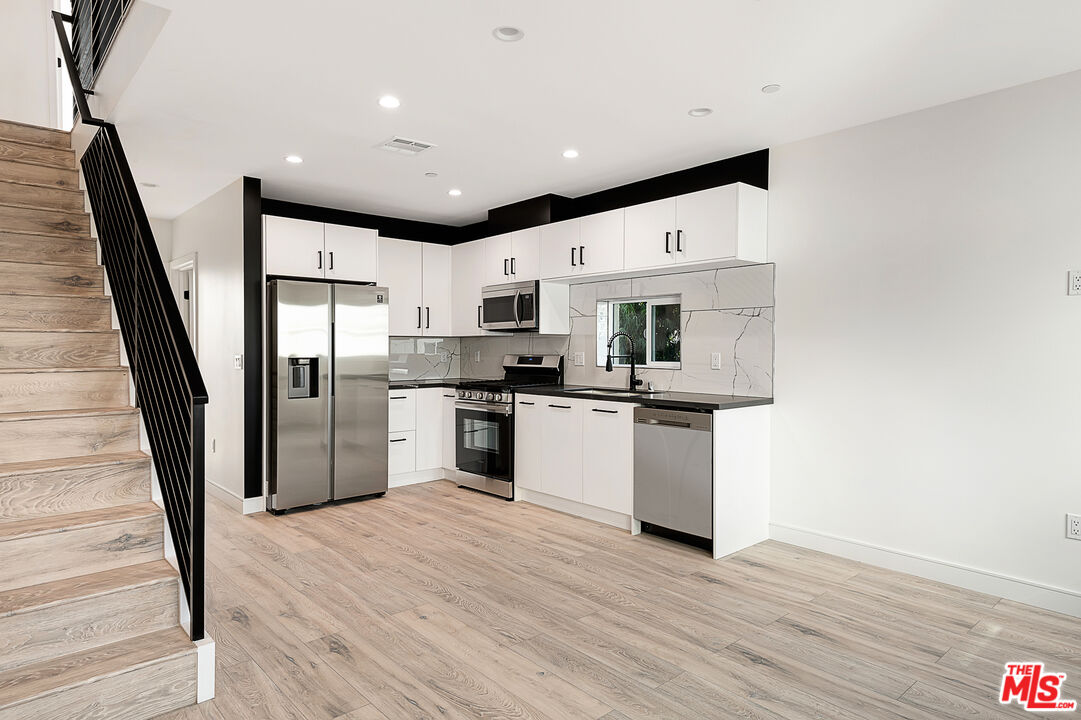 5464 Geer Street Los Angeles, CA 90016 - Photo 2 of 21 a kitchen with stainless steel appliances a refrigerator and a wooden floor