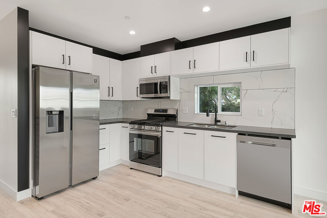 5464 Geer Street Los Angeles, CA 90016 - Photo 5 of 21 a kitchen with stainless steel appliances a refrigerator stove microwave and sink