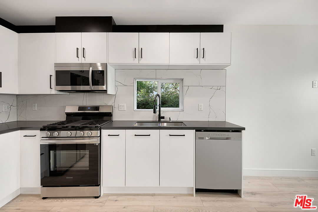 5464 Geer Street Los Angeles, CA 90016 - Photo 6 of 21 a kitchen with stainless steel appliances a stove microwave and sink