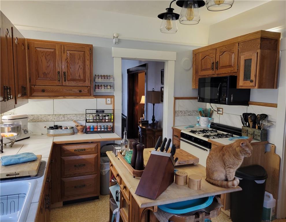 276 13th Street Ambridge, PA 15003 - Photo 8 of 25 a kitchen with granite countertop a stove a sink dishwasher a dining table and chairs with wooden floor