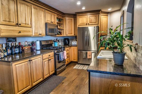 1236 Mountain View Drive Ridgecrest, CA 93555 - Photo 13 of 38 a kitchen with stainless steel appliances granite countertop a refrigerator a stove and a sink