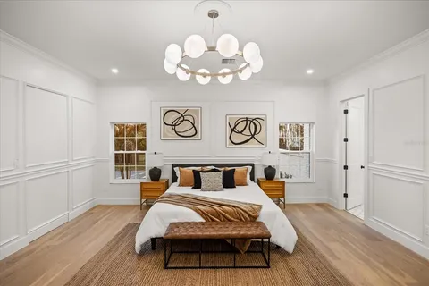 a bedroom with a bed and a chandelier