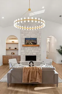 a kitchen with stainless steel appliances granite countertop a stove a sink dishwasher a refrigerator and white cabinets with wooden floor