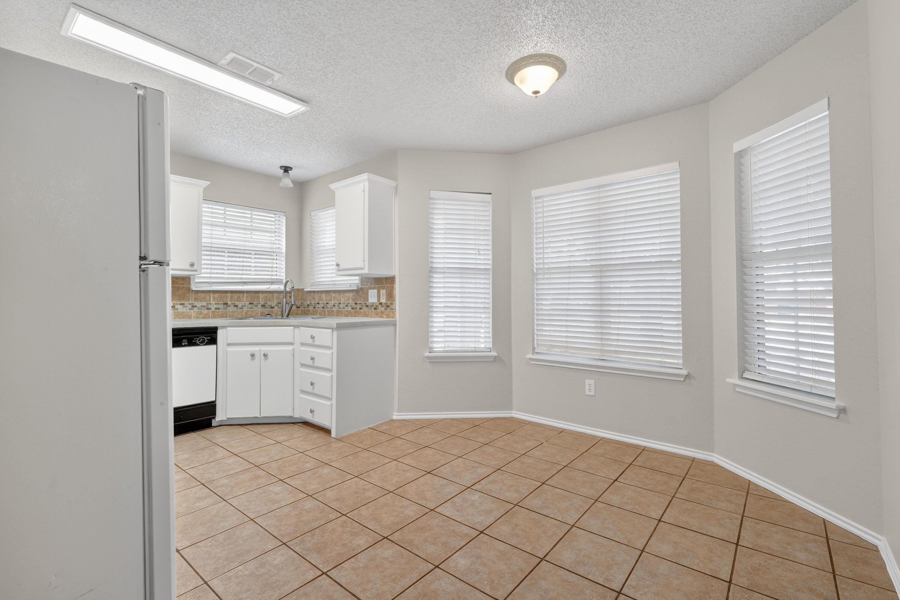 1805 75th Street Lubbock, TX 79423 - Photo 5 of 20 a kitchen with a stove cabinets and a refrigerator