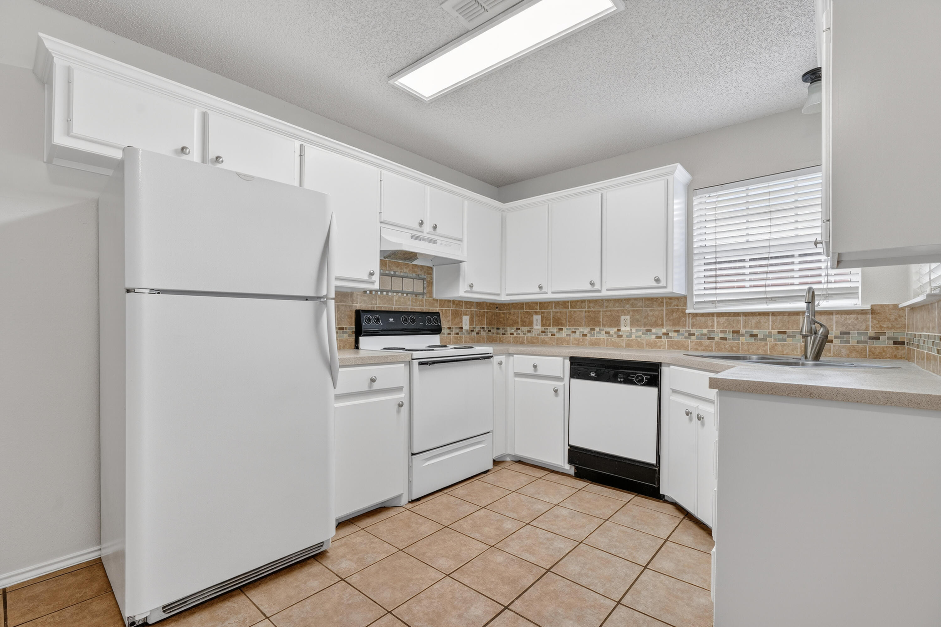 1805 75th Street Lubbock, TX 79423 - Photo 7 of 20 a kitchen with white cabinets and white appliances