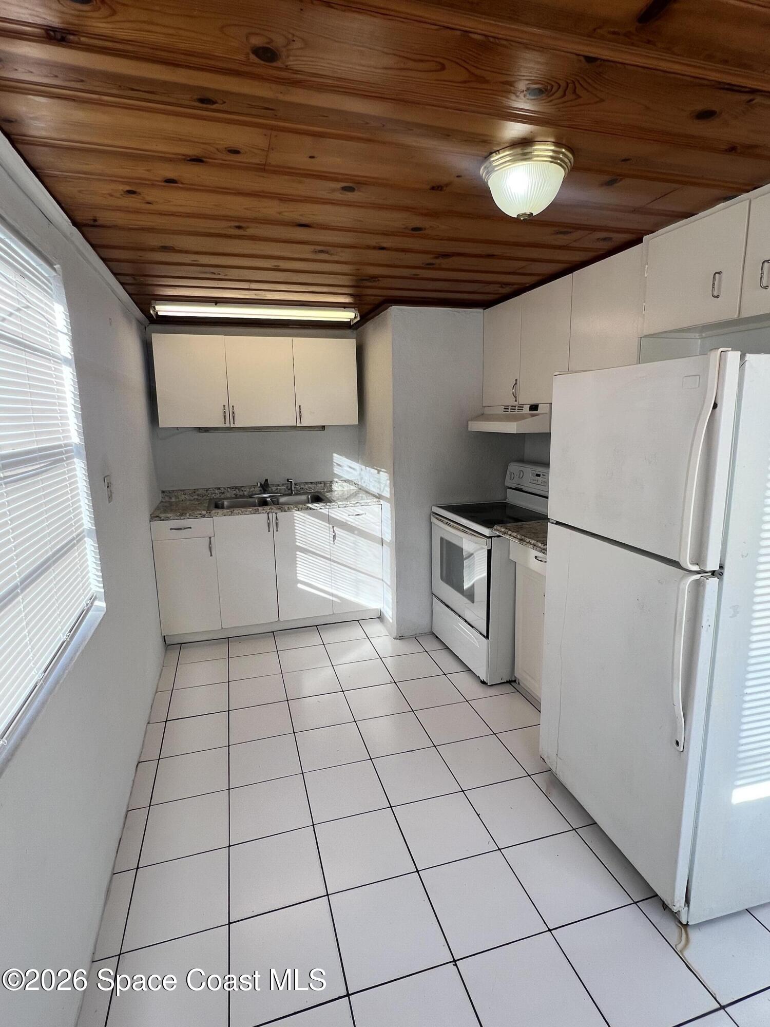 441 Vickers Street, Unit A Melbourne, FL 32935 - Photo 7 of 19 a kitchen with stainless steel appliances a refrigerator sink and cabinets