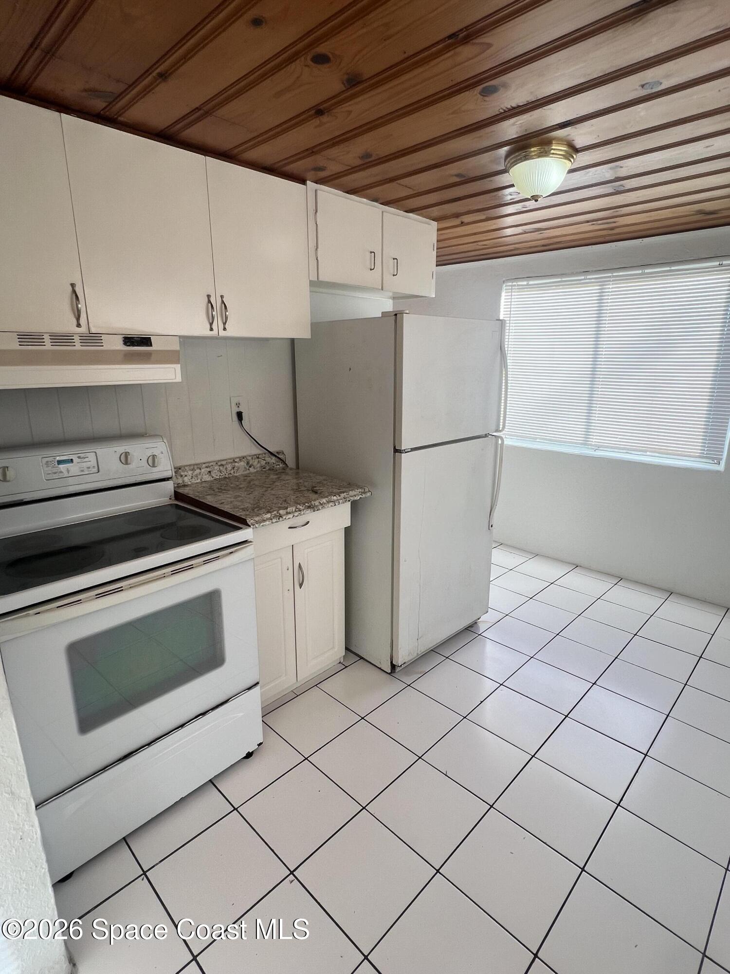 441 Vickers Street, Unit A Melbourne, FL 32935 - Photo 8 of 19 a kitchen with a stove cabinets and white appliances