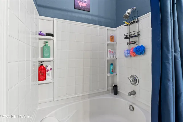 a bedroom with two beds and painting on the wall