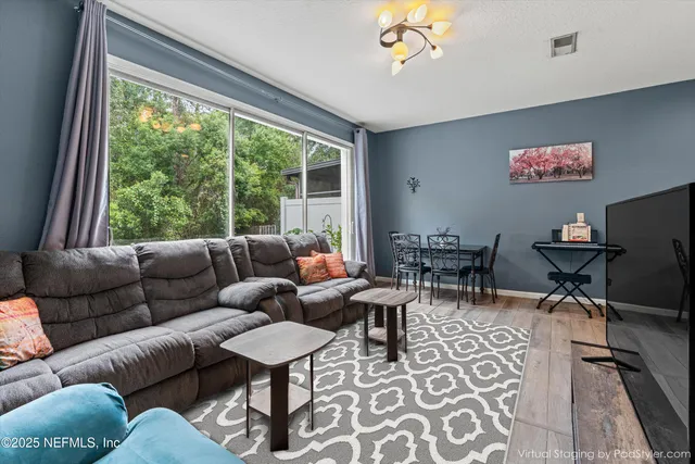 a living room with furniture a rug and a large window
