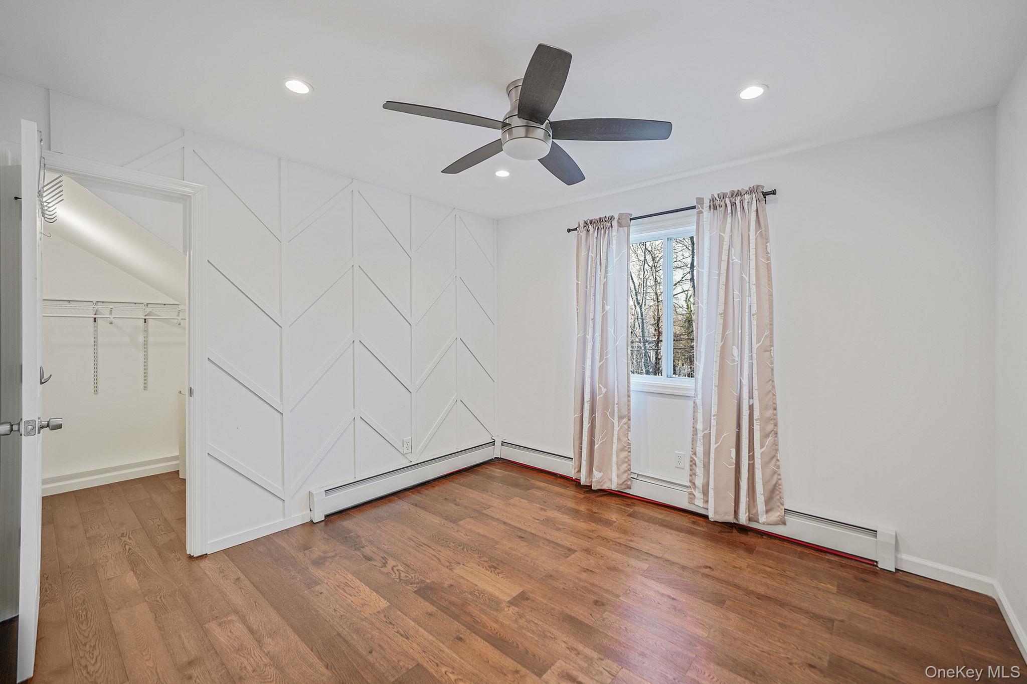 38 Hawthorne Road Rocky Point, NY 11778 - Photo 19 of 30 Bedroom featuring wood finished floors, a spacious closet, a ceiling fan, recessed lighting, and a baseboard radiator