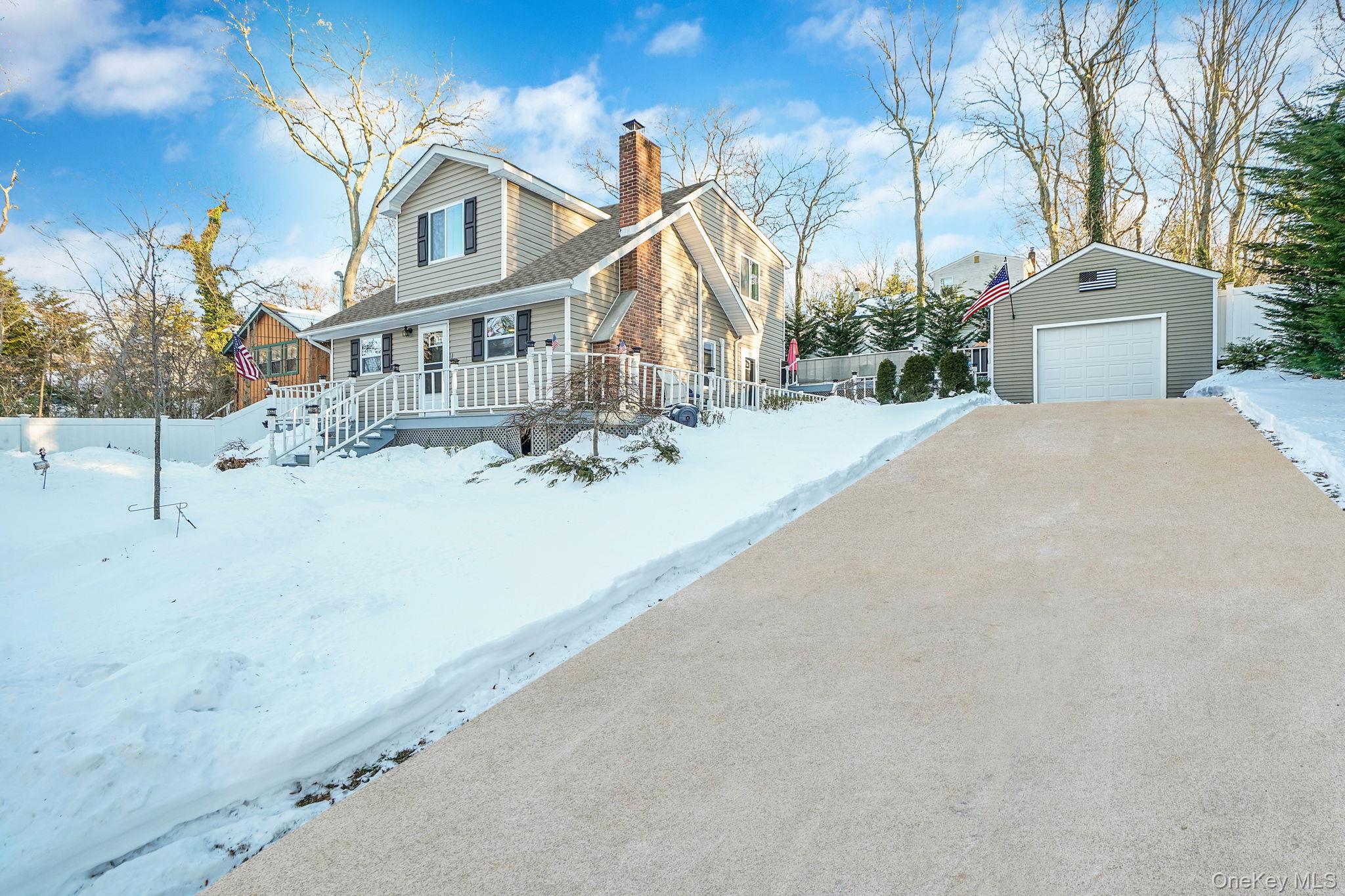 38 Hawthorne Road Rocky Point, NY 11778 - Photo 3 of 30 View of front facade featuring an outdoor structure, a chimney, a garage, and a deck