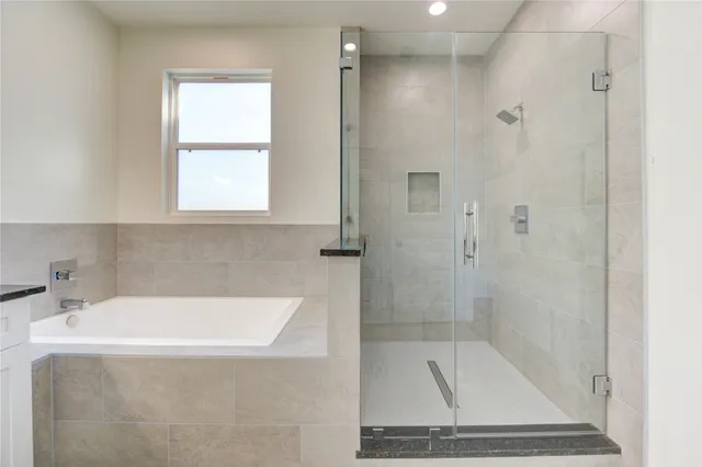 a bathroom with a tub shower sink and vanity