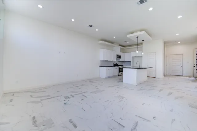 a large white kitchen with white cabinets and white stainless steel appliances