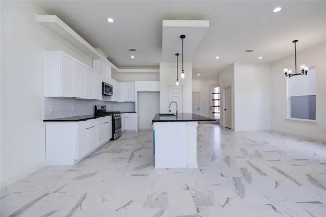 a large kitchen with cabinets and stainless steel appliances