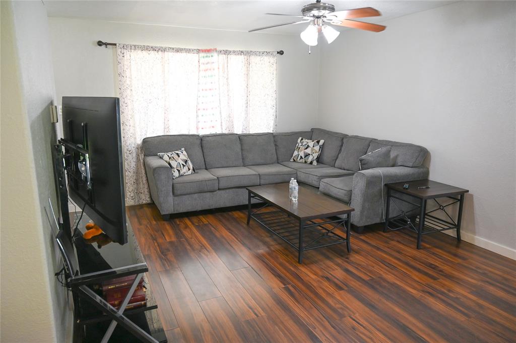 1352 Simpson Drive Hurst, TX 76053 - Photo 38 of 40 Spacious living area featuring rich wood-finish flooring, a ceiling fan with integrated lighting, and neutral wall tones