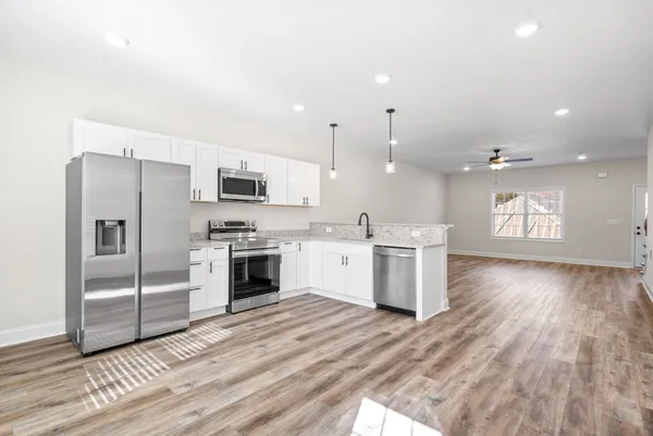 a kitchen with a refrigerator and a stove top oven