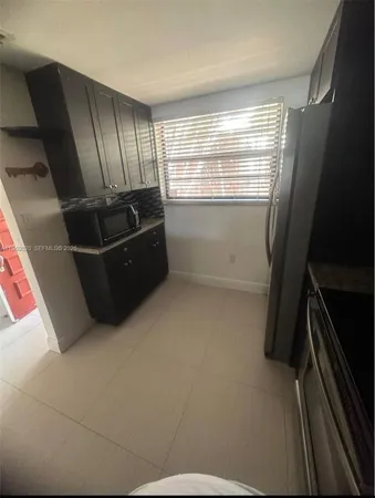 a kitchen with granite countertop stainless steel appliances a sink a stove and a counter top
