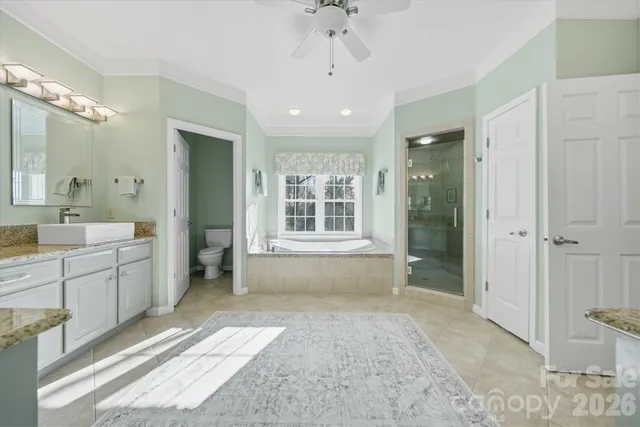 a spacious bathroom with a double vanity sink a large mirror and a bathtub