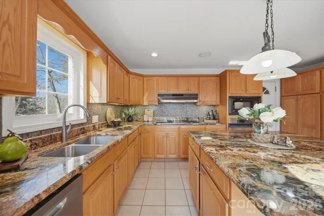 a kitchen with kitchen island granite countertop a sink counter top space appliances and cabinets