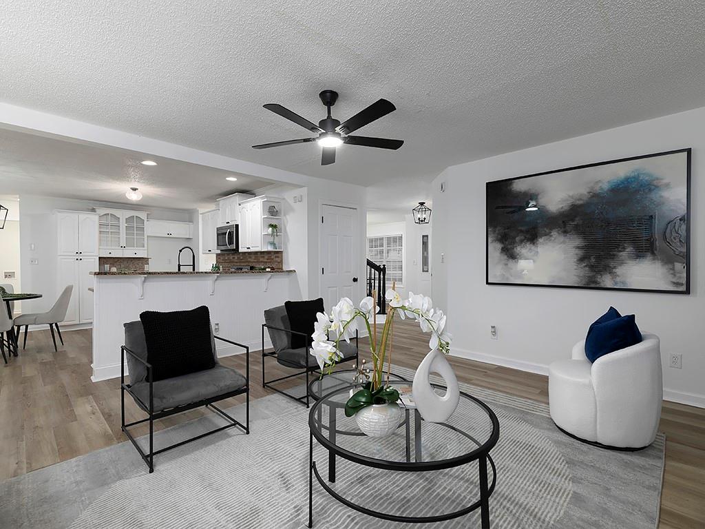 62 Smoak Field Road Griffin, GA 30223 - Photo 18 of 50 a living room with couches a coffee table and kitchen view with wooden floor