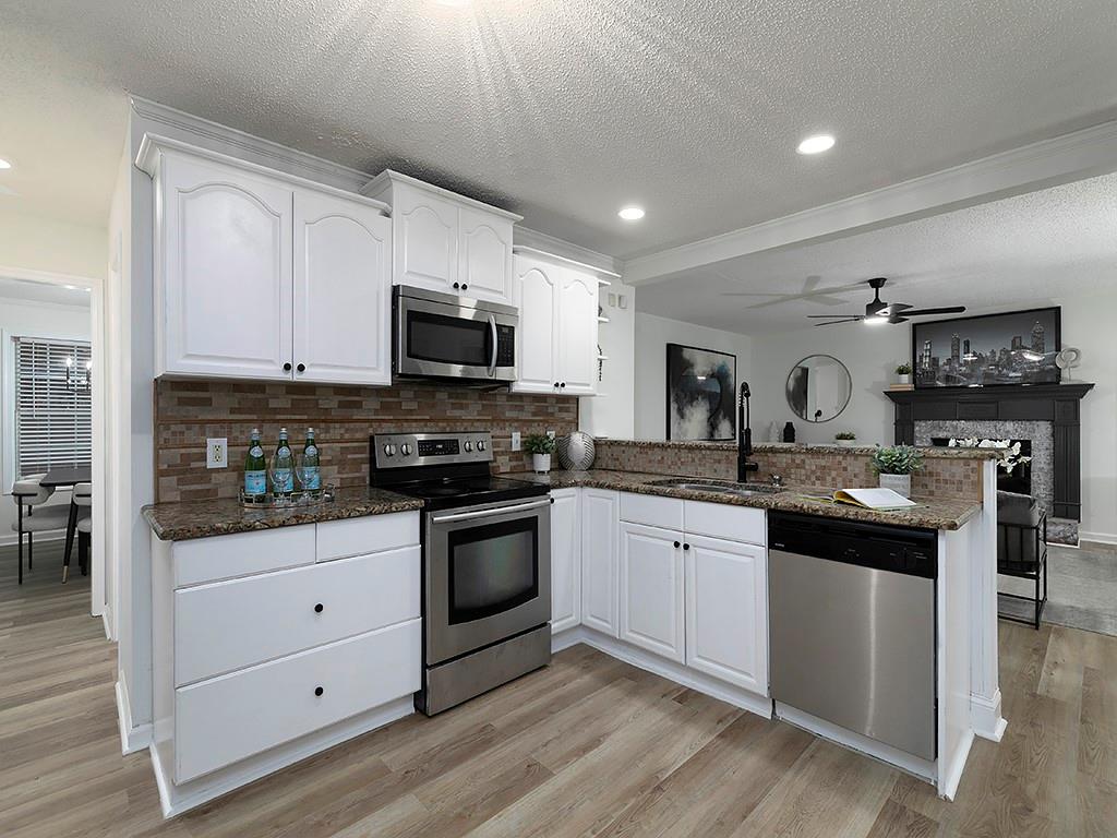 62 Smoak Field Road Griffin, GA 30223 - Photo 20 of 50 a kitchen with stainless steel appliances granite countertop a stove top oven a sink and a microwave