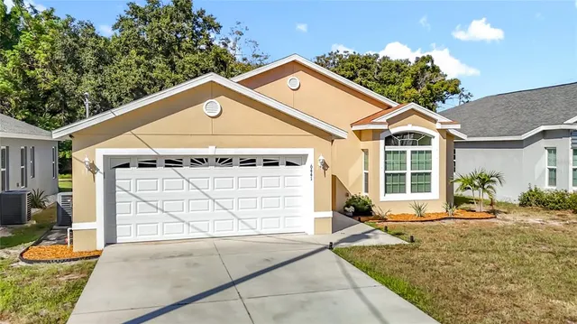 a front view of a house with a yard and potted plants