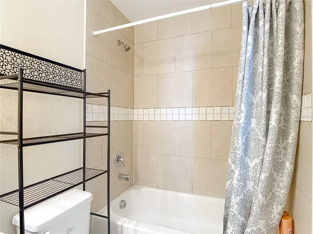 an empty room with a ceiling fan and a window