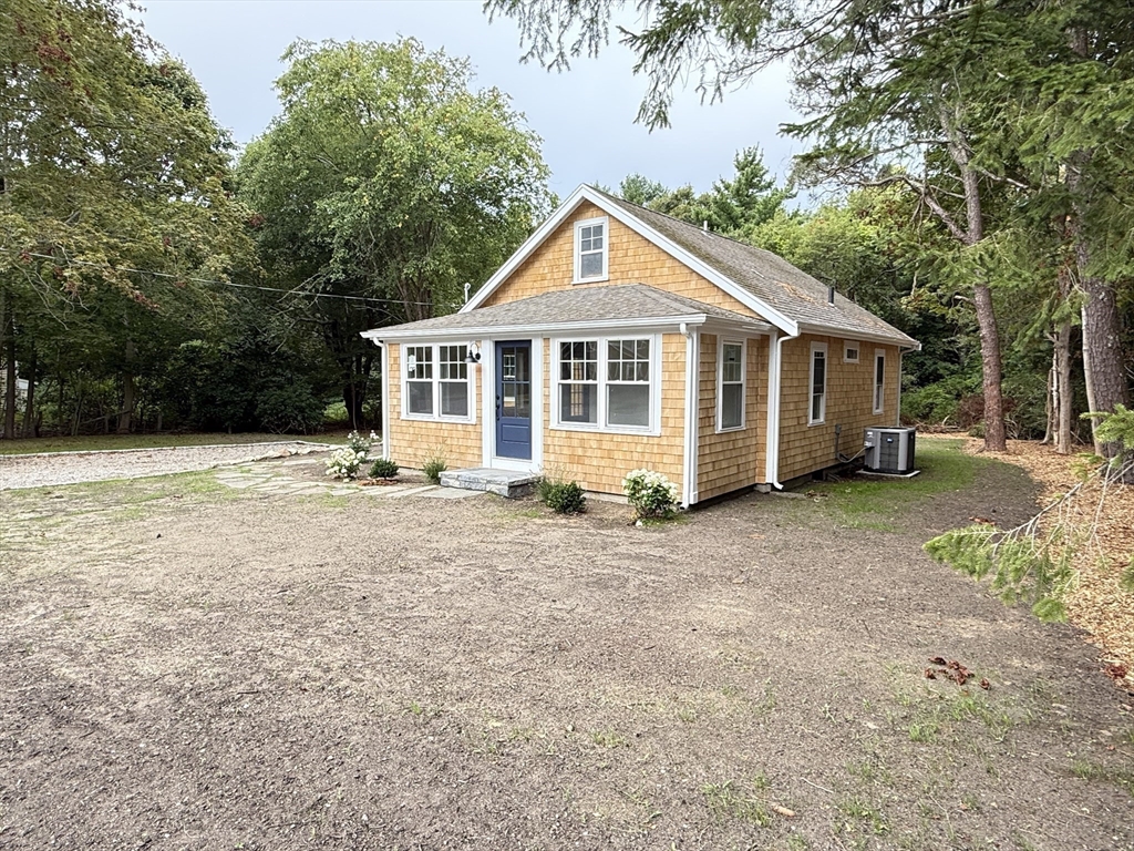 1469 Santuit-Newtown Road Barnstable, MA 02635 - Photo 3 of 18 a front view of a house with a yard and garage