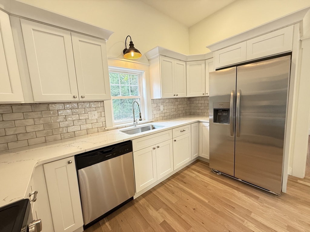 1469 Santuit-Newtown Road Barnstable, MA 02635 - Photo 8 of 18 a kitchen with white cabinets and window