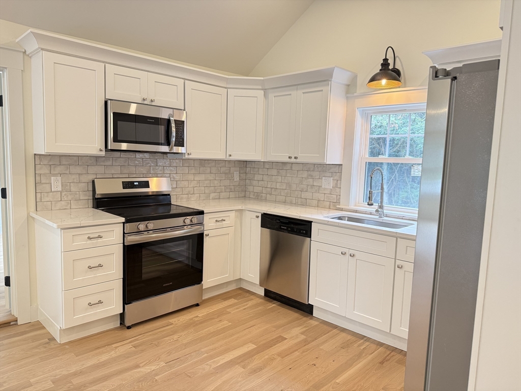 1469 Santuit-Newtown Road Barnstable, MA 02635 - Photo 9 of 18 a kitchen with stainless steel appliances granite countertop a stove a sink and a microwave