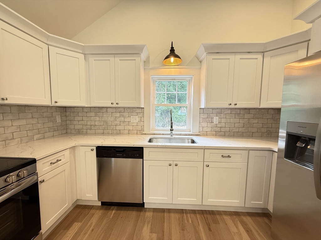 1469 Santuit-Newtown Road Barnstable, MA 02635 - Photo 10 of 18 a kitchen with stainless steel appliances a sink cabinets and wooden floor