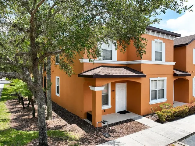 a view of a white house with large windows and a tree