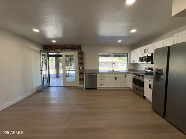 a view of a kitchen with a sink and stainless steel appliances