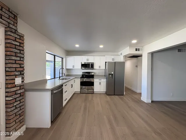 a large kitchen with stainless steel appliances granite countertop a large counter top and a stove