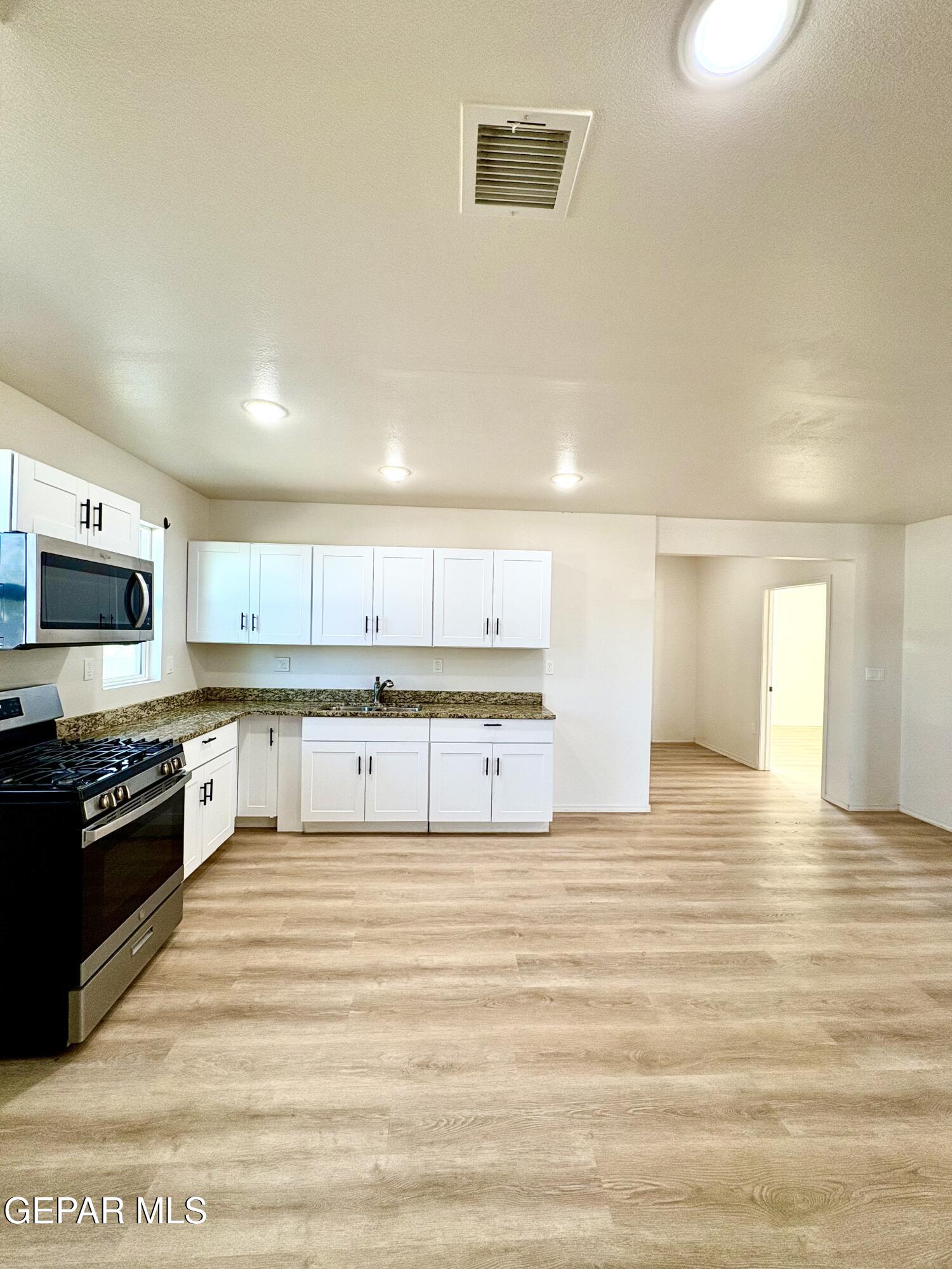 11420 Doris Road Socorro, TX 79927 - Photo 7 of 27 a kitchen with stainless steel appliances granite countertop a stove and a refrigerator