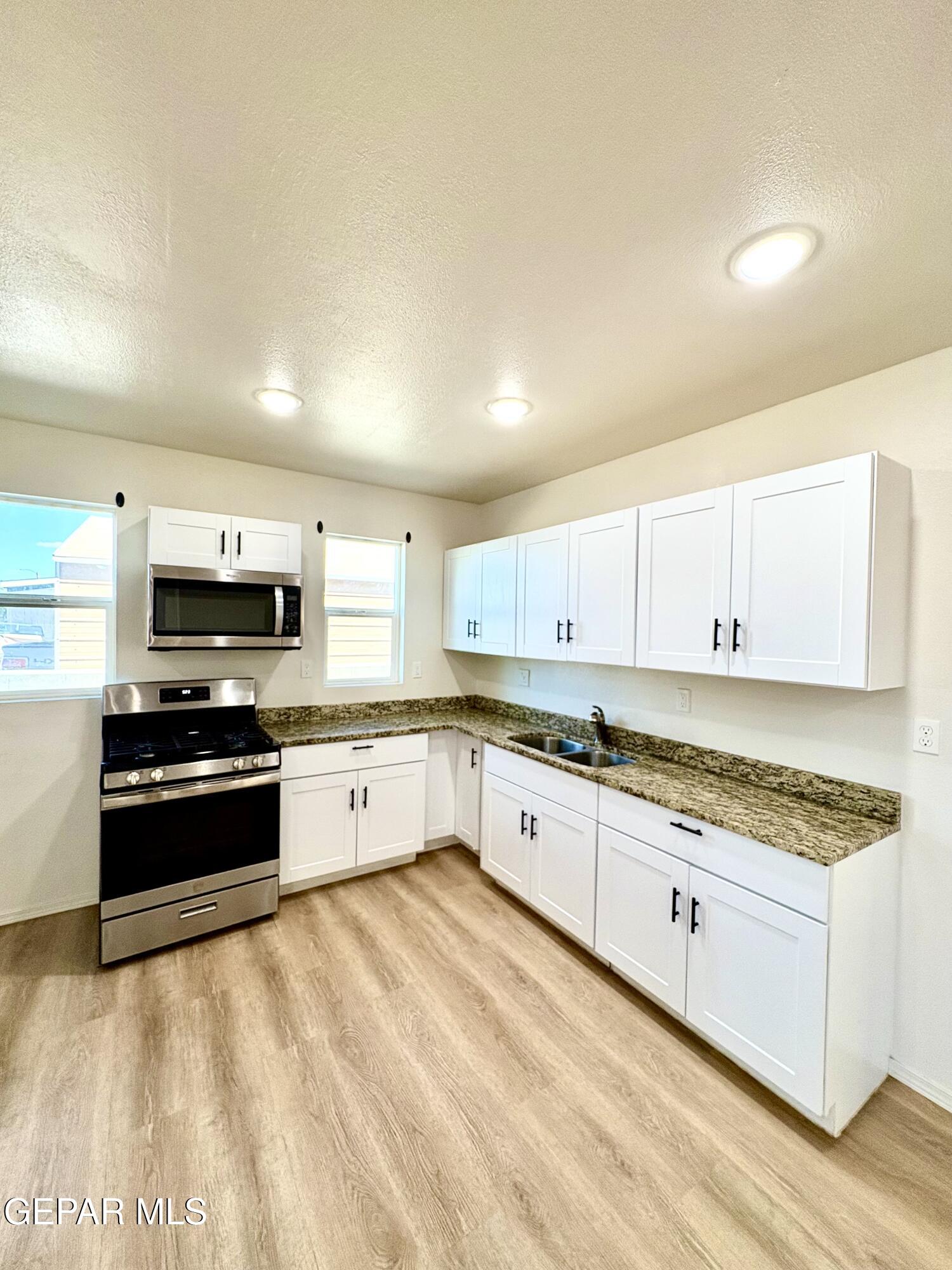 11420 Doris Road Socorro, TX 79927 - Photo 10 of 27 a large kitchen with stainless steel appliances granite countertop a stove a sink and a white cabinets