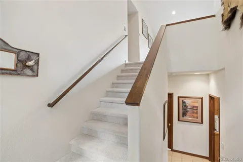 a view of staircase with lots of frames on wall and stairs