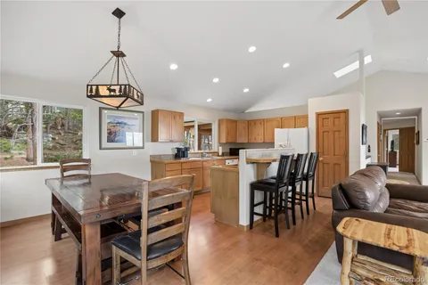 a dining room with furniture a chandelier and wooden floor